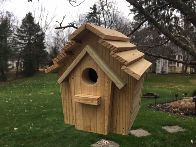 wooden birdhouse hanging in yard