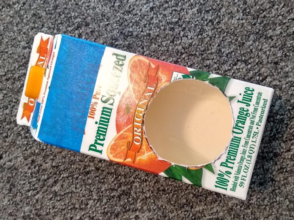 empty orange juice carton with circle cut out