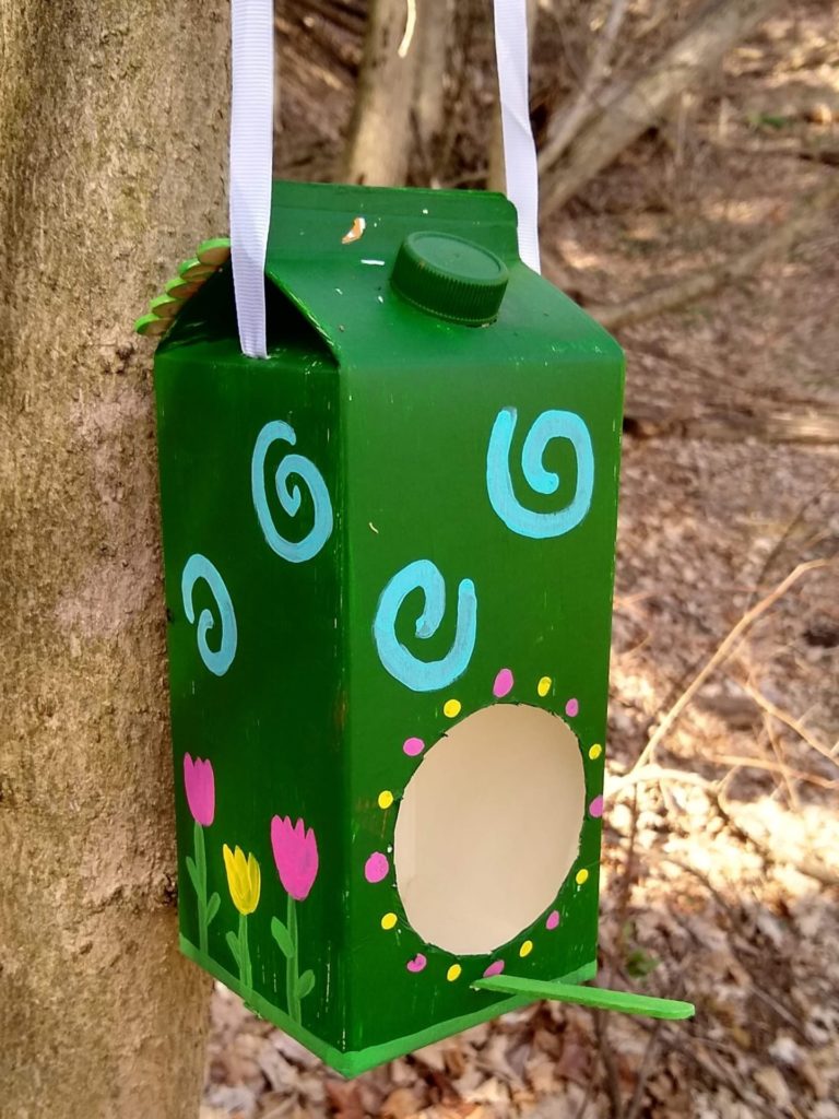 Final DIY birdhouse hanging outside on tree branch