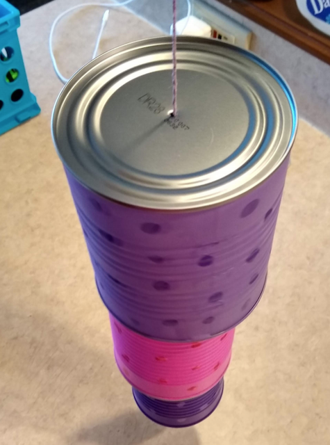 Different sized cans stacked on the string.