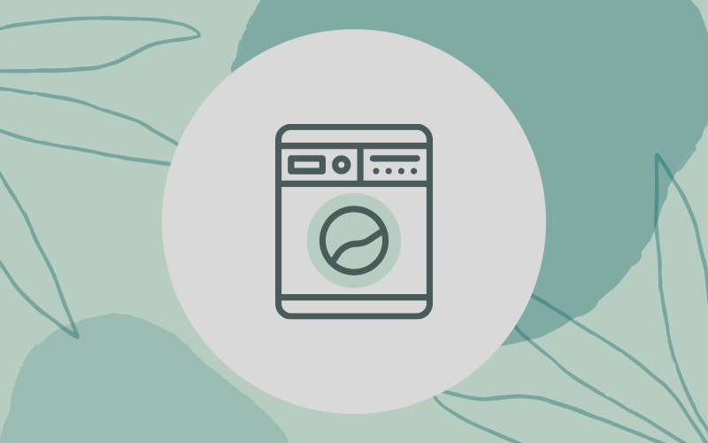 Washing machine on green, leafy background