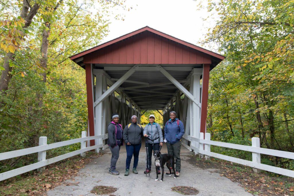 Conservancy staff photo of JOY group standing near covered bridge