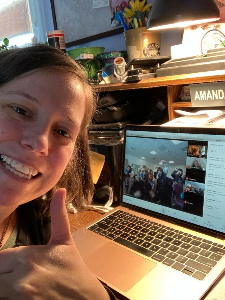 Education specialist Amanda smiles for a selfie in front of her laptop for virtual learning