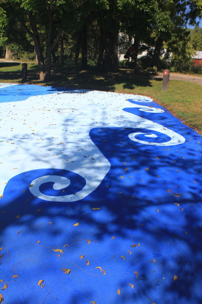 Blue and white swirls painted on the parking lot at Boston Store.