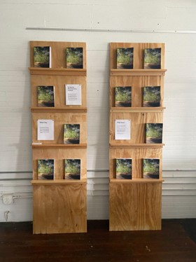 Two shelves with books about project on exhibit.