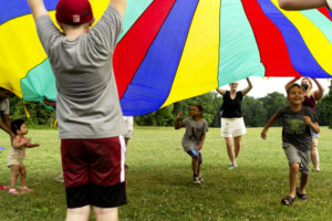 Children playing with a colorful parachute