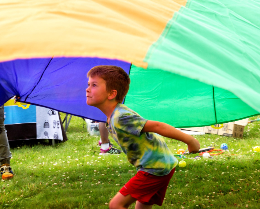 Child running under parachute.