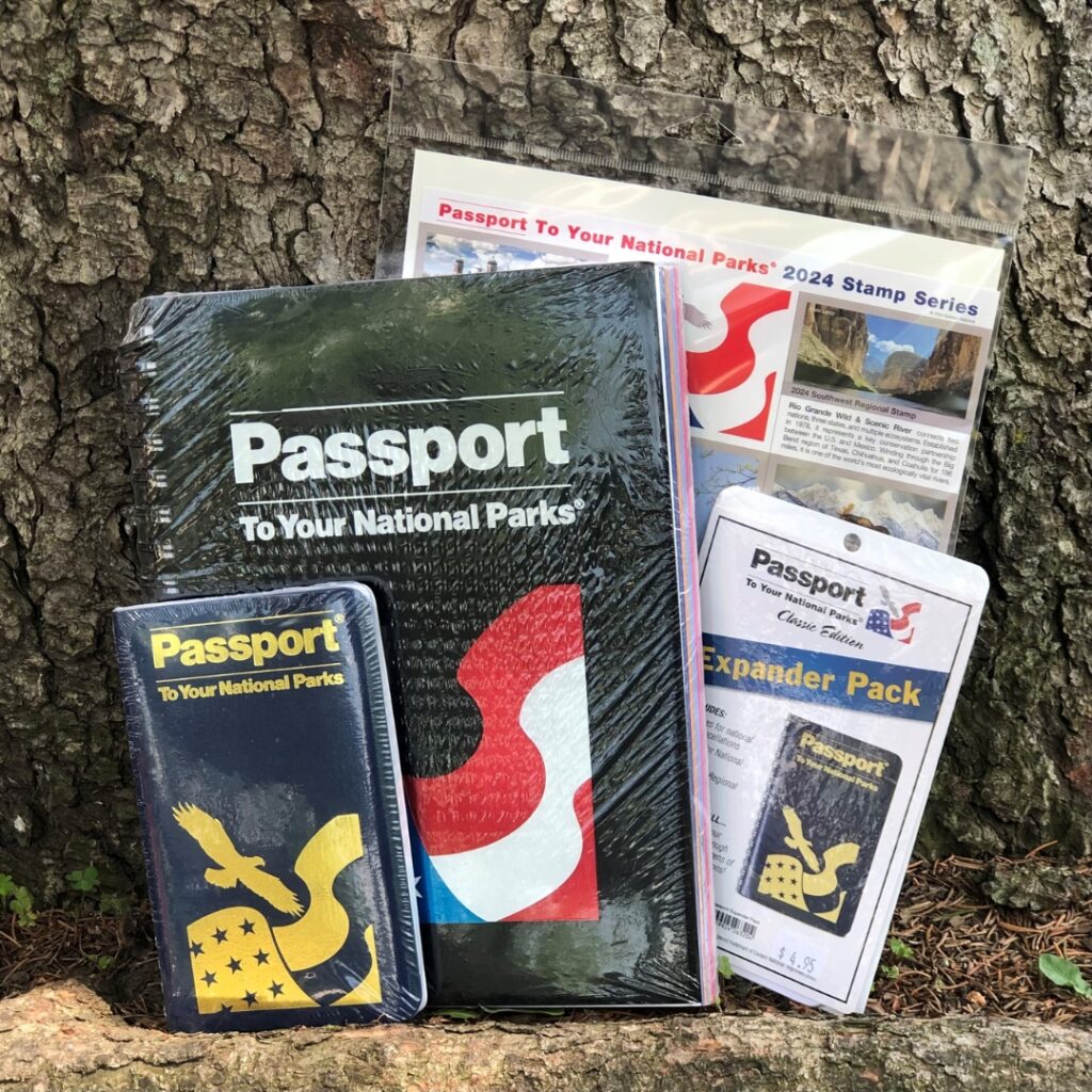 A photo of a national park passport book and other related national park passport add-ons.