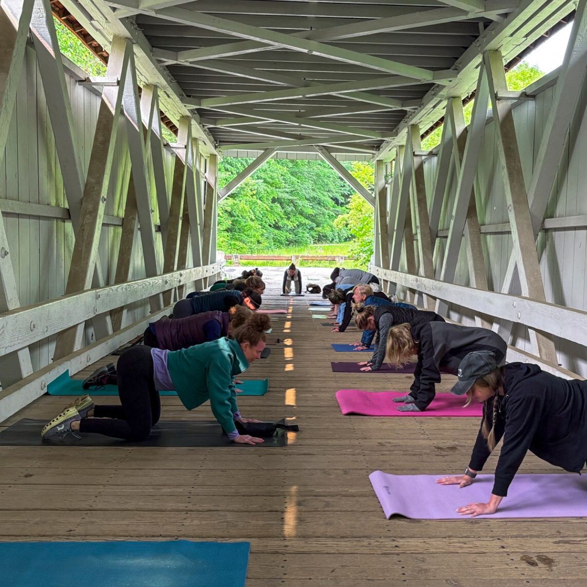 A photo of people doing yoga inside of the Everett Covered Bridge in Cuyahoga Valley National Park.